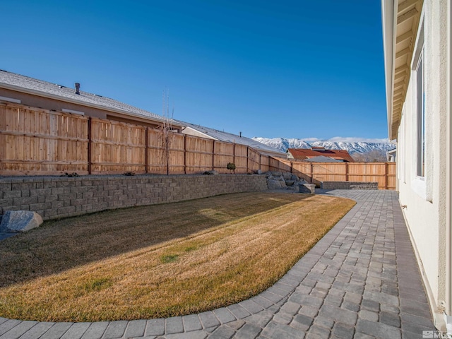 view of yard featuring a patio and a mountain view