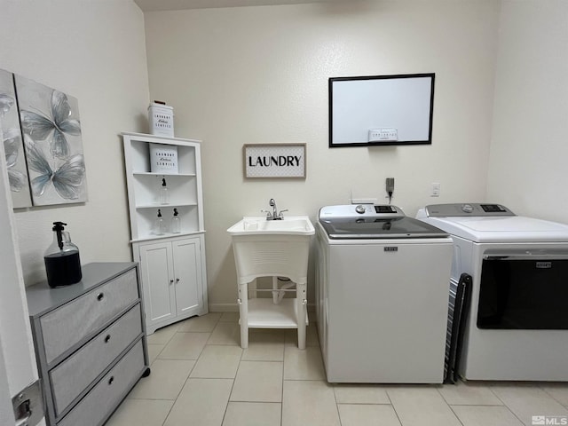 laundry area featuring separate washer and dryer, cabinets, and light tile patterned flooring