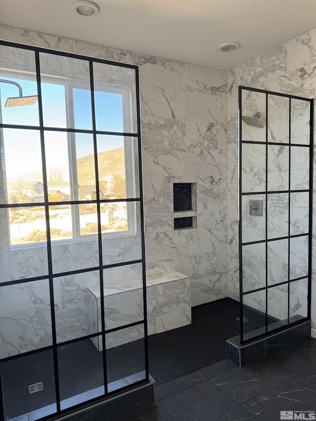 bathroom featuring a textured ceiling and tiled shower