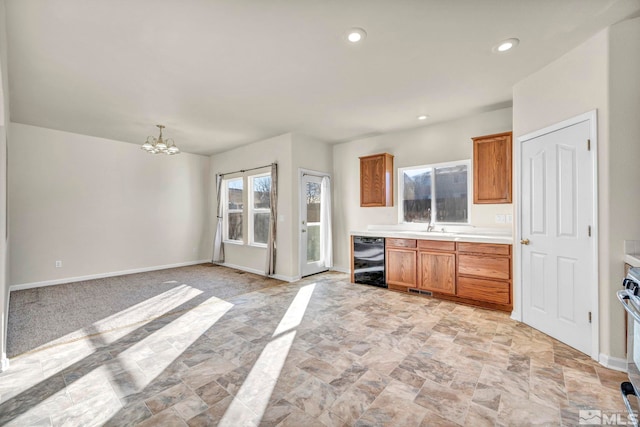 kitchen with sink, stove, a chandelier, and wine cooler