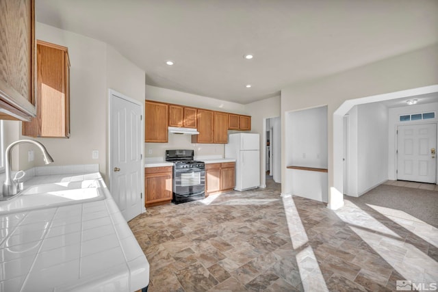 kitchen featuring white refrigerator, black range with gas stovetop, and sink