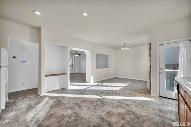 interior space with dishwashing machine, white fridge, a wealth of natural light, and ceiling fan with notable chandelier