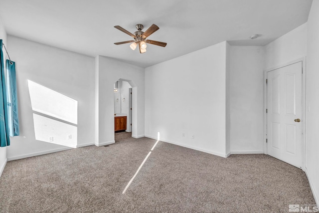 unfurnished bedroom featuring ensuite bathroom, carpet floors, and ceiling fan