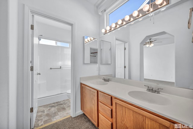 bathroom featuring toilet, a shower with door, ceiling fan, and a healthy amount of sunlight