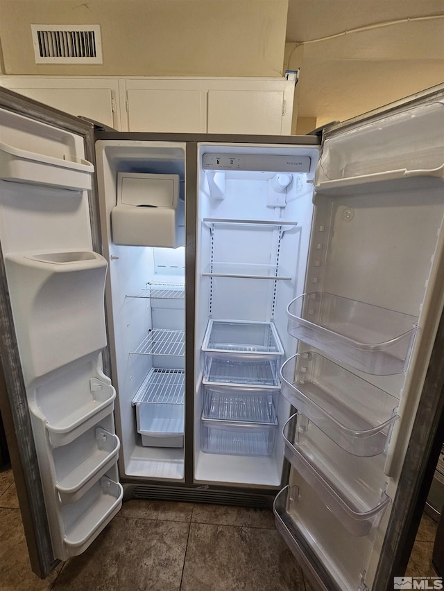 room details with refrigerator and white cabinetry