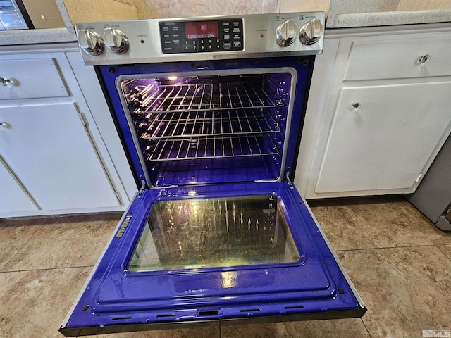 room details featuring blue cabinets, white cabinets, and range