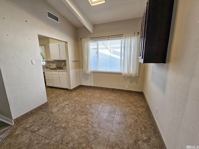 spare room featuring lofted ceiling and sink