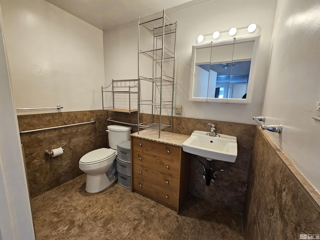 bathroom with sink, tile walls, and toilet