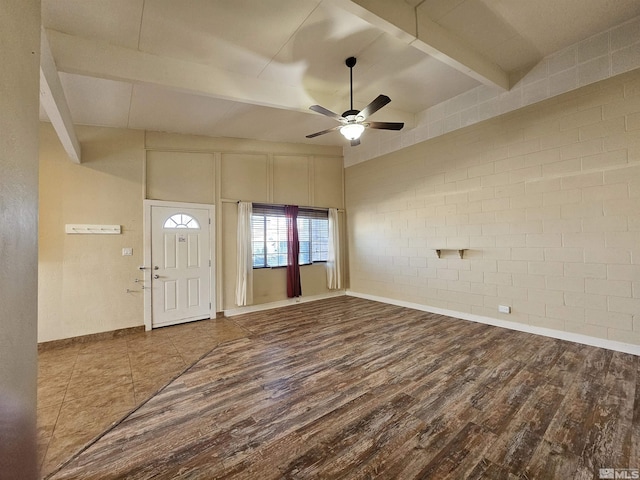 entrance foyer featuring brick wall, wood-type flooring, ceiling fan, and beamed ceiling