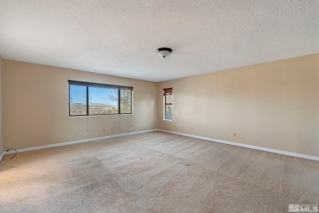 carpeted spare room with a textured ceiling