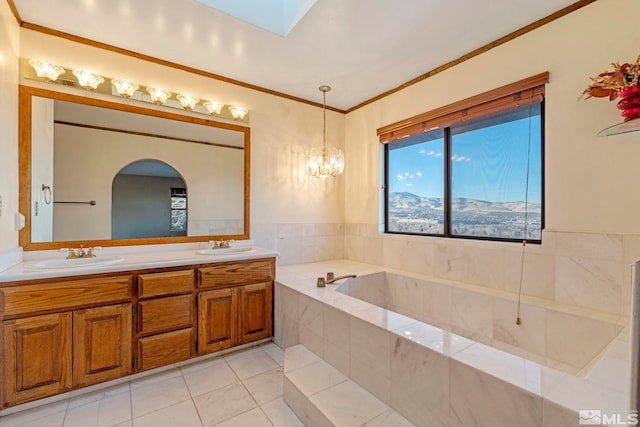 bathroom with tile patterned flooring, tiled bath, crown molding, vanity, and an inviting chandelier