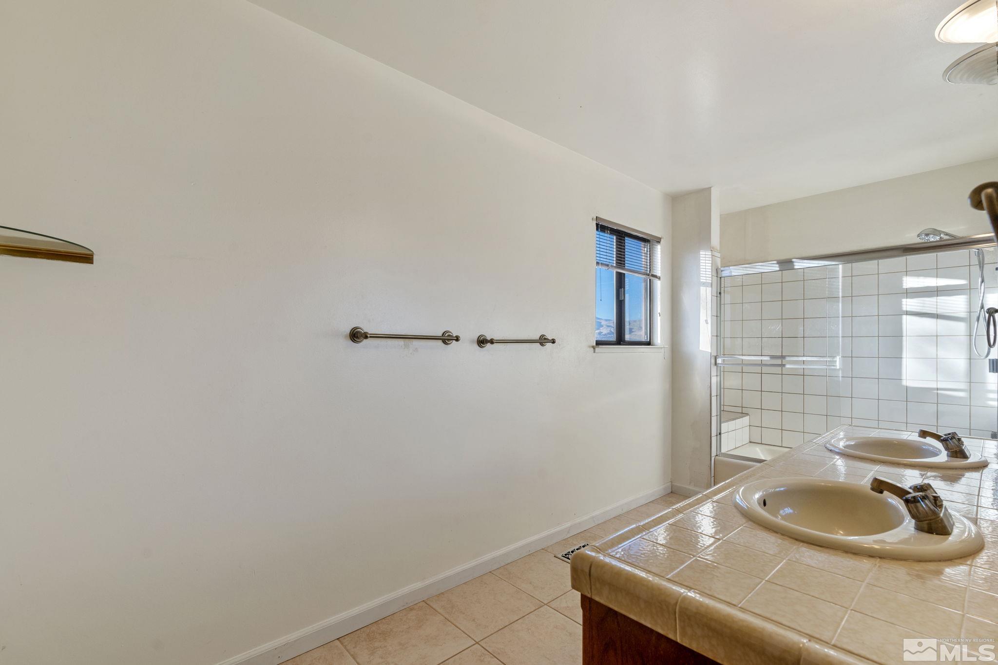 bathroom featuring a shower, vanity, and tile patterned floors