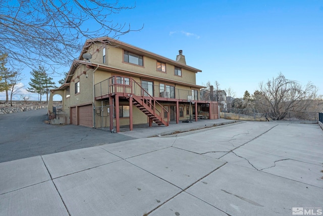 rear view of property with a garage and a wooden deck