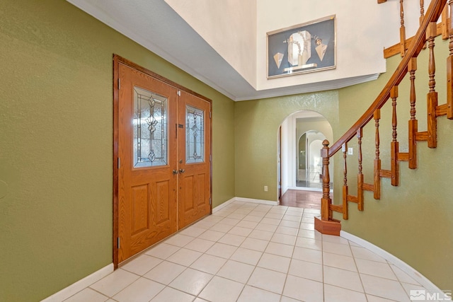 tiled foyer featuring ornamental molding