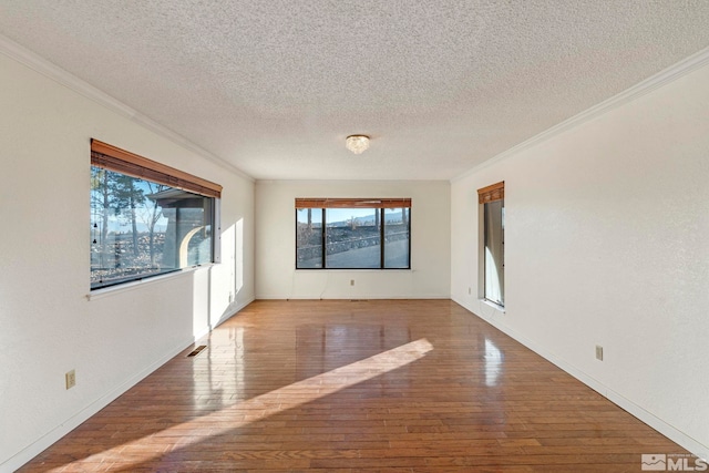 unfurnished room with hardwood / wood-style flooring, a textured ceiling, and crown molding