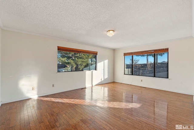 unfurnished room featuring ornamental molding, a textured ceiling, and wood-type flooring