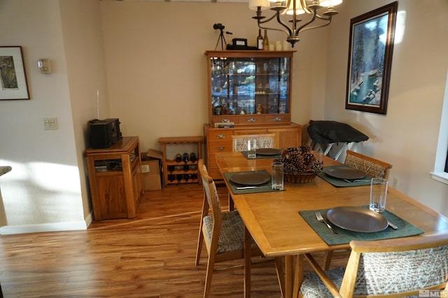 dining room featuring wood-type flooring and an inviting chandelier