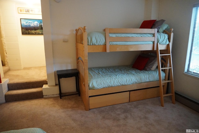 bedroom with a baseboard heating unit, multiple windows, and carpet