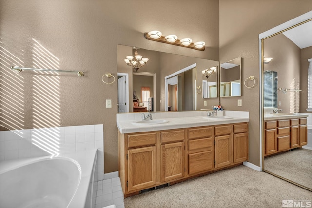 bathroom featuring a washtub, a chandelier, and vanity