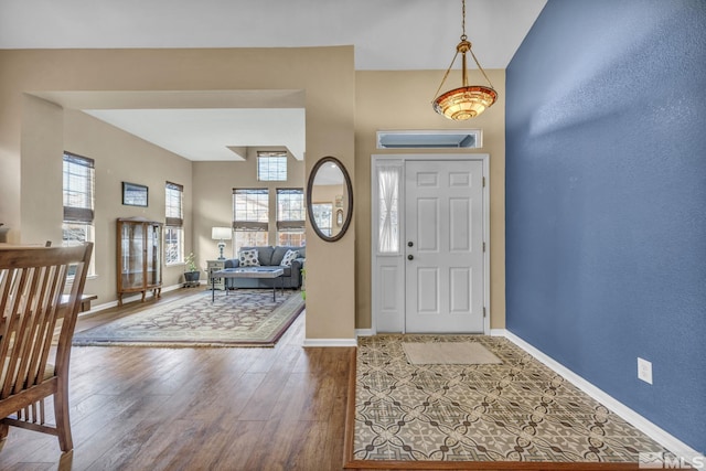 entryway with a towering ceiling and hardwood / wood-style flooring