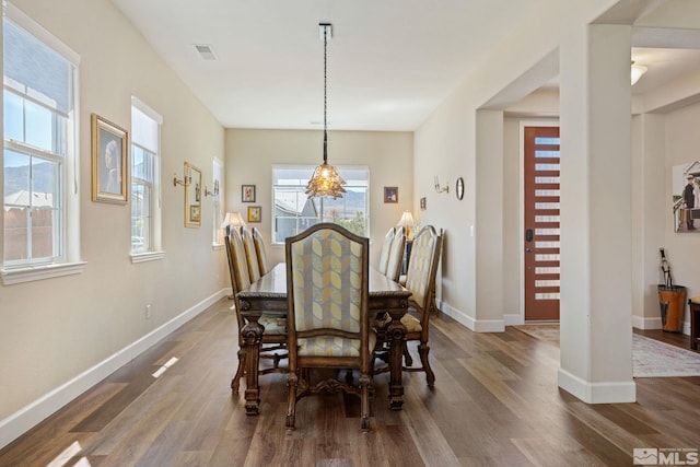 dining room featuring an inviting chandelier and dark wood-type flooring