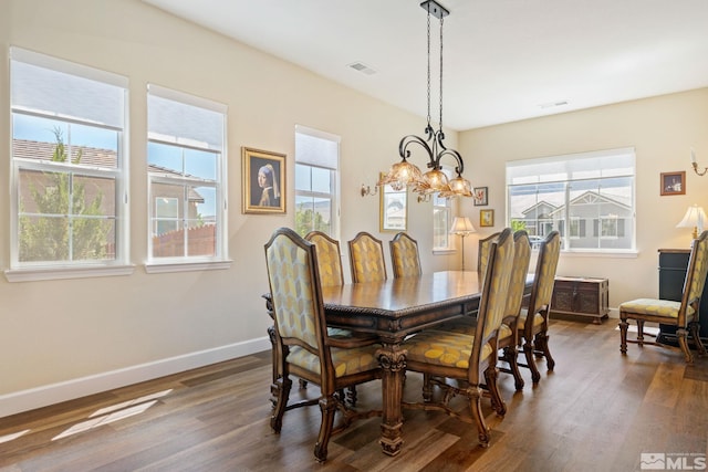 dining area featuring a notable chandelier and dark hardwood / wood-style flooring