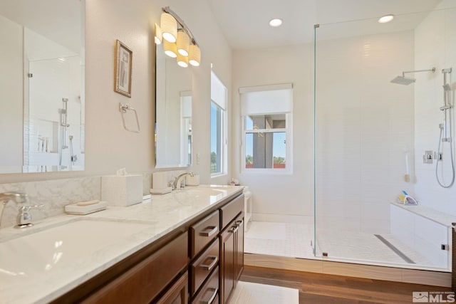 bathroom with a tile shower and vanity