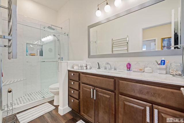 bathroom with toilet, vanity, a shower with shower door, and hardwood / wood-style flooring