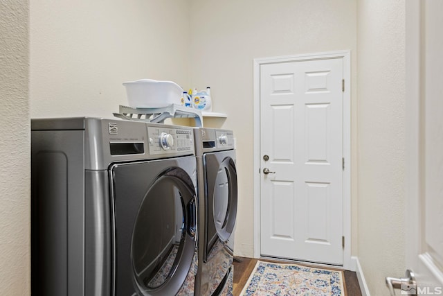 laundry area with dark hardwood / wood-style flooring and independent washer and dryer