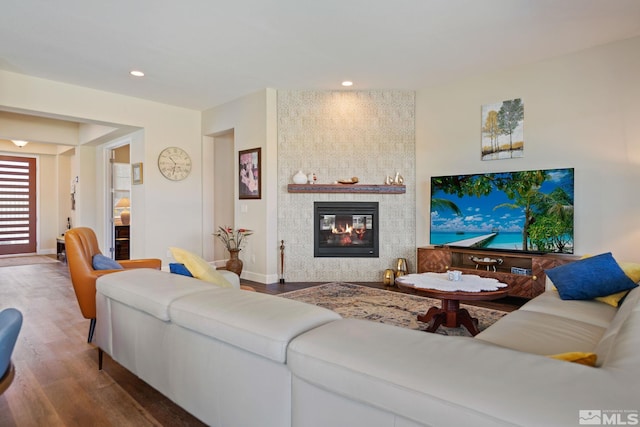 living room with a large fireplace and dark hardwood / wood-style floors