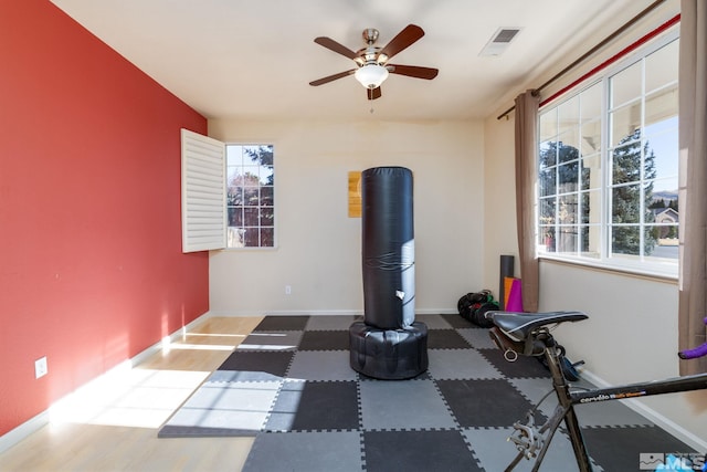 exercise room featuring ceiling fan and a wealth of natural light