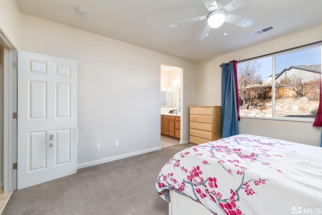 bedroom with ensuite bathroom, light colored carpet, ceiling fan, and sink