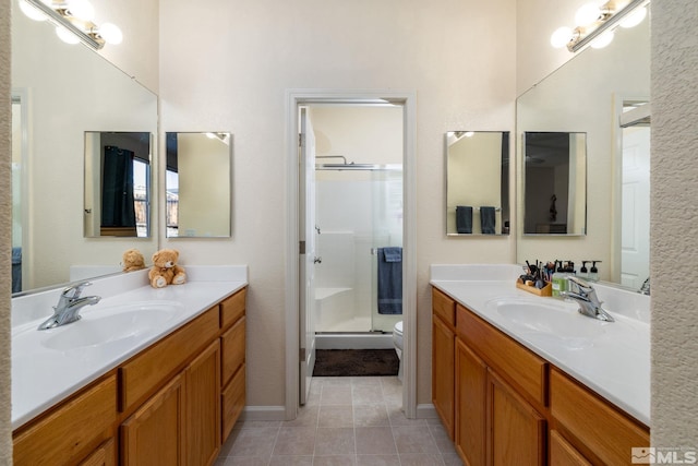 bathroom featuring tile patterned floors, an enclosed shower, vanity, and toilet