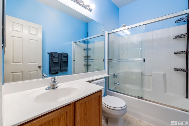 full bathroom with shower / bath combination with glass door, tile patterned flooring, toilet, and vanity