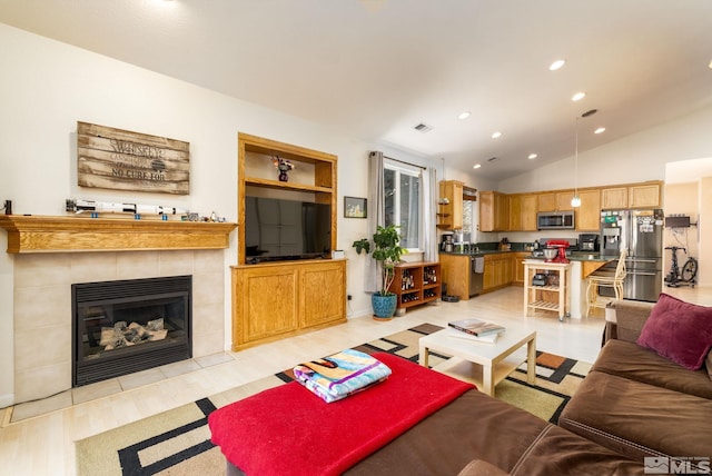 living room featuring lofted ceiling, a fireplace, and light hardwood / wood-style flooring