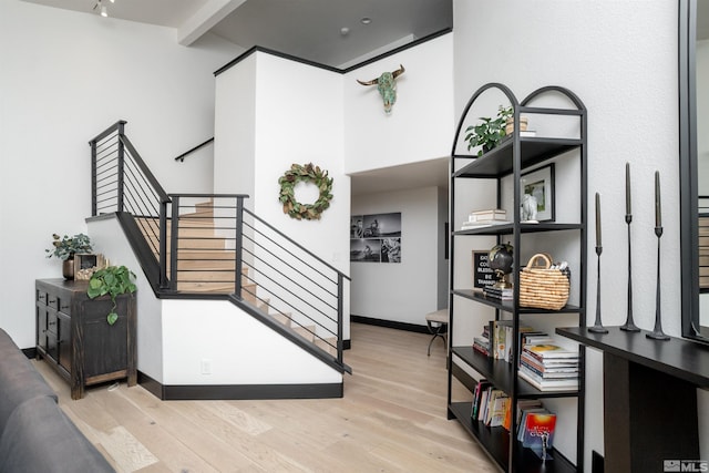 interior space featuring beam ceiling and light hardwood / wood-style flooring