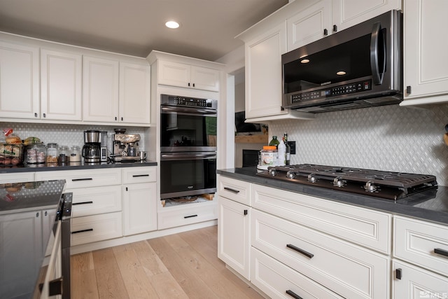 kitchen featuring stainless steel appliances, light hardwood / wood-style floors, white cabinets, and tasteful backsplash