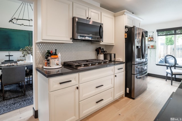 kitchen featuring white cabinets, tasteful backsplash, light hardwood / wood-style flooring, and appliances with stainless steel finishes