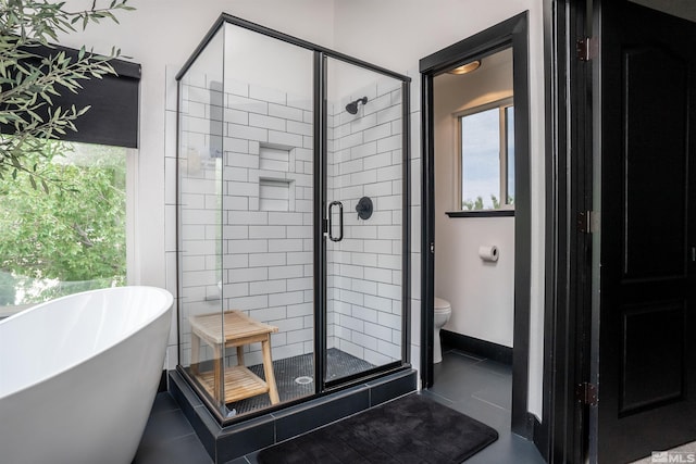 bathroom featuring toilet, tile patterned floors, plenty of natural light, and plus walk in shower