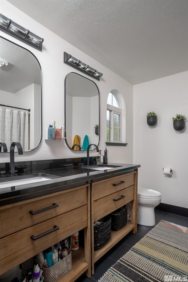 bathroom with toilet, tile patterned flooring, a textured ceiling, and vanity