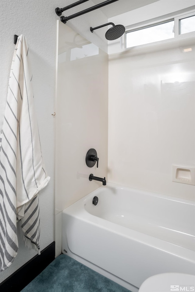 bathroom featuring toilet and bathtub / shower combination