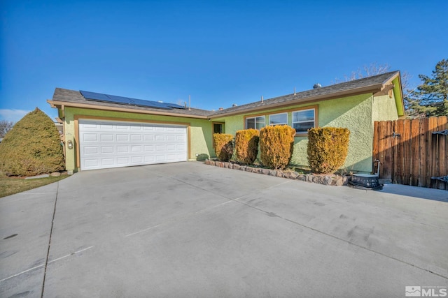 ranch-style house with solar panels and a garage