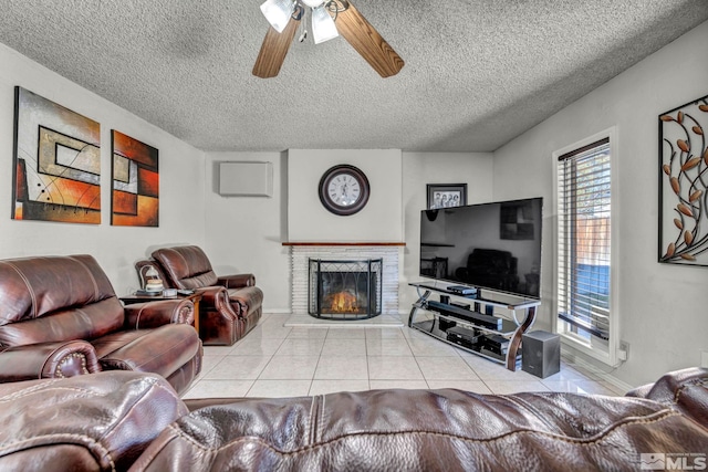 living room featuring a textured ceiling, ceiling fan, and light tile patterned floors