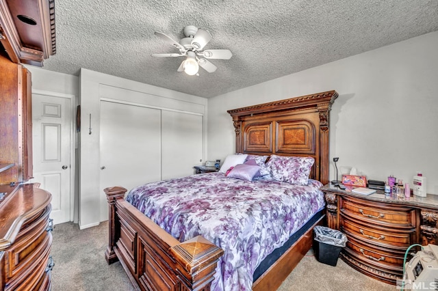 bedroom with ceiling fan, a closet, light carpet, and a textured ceiling