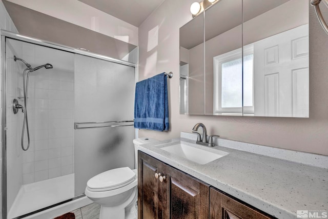 bathroom with toilet, a shower with door, and vanity