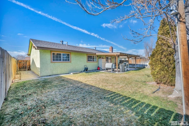 back of house with a patio area and a lawn