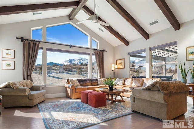 living room with a mountain view, hardwood / wood-style floors, high vaulted ceiling, beam ceiling, and ceiling fan