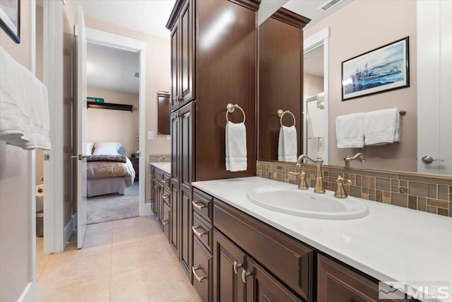 bathroom with tile patterned floors, tasteful backsplash, and vanity