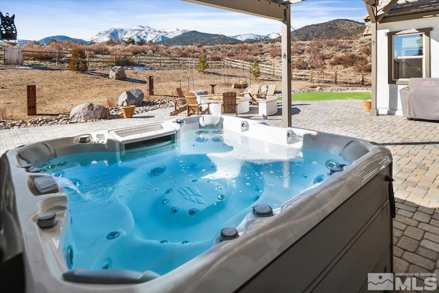 view of pool with a mountain view, a patio, and a hot tub