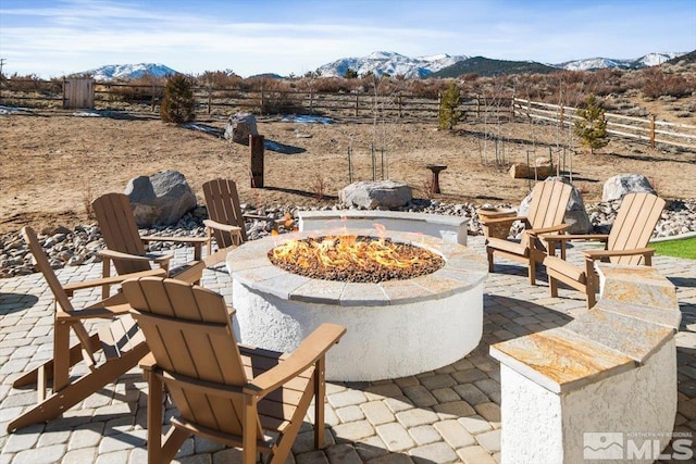 view of patio with an outdoor fire pit and a mountain view